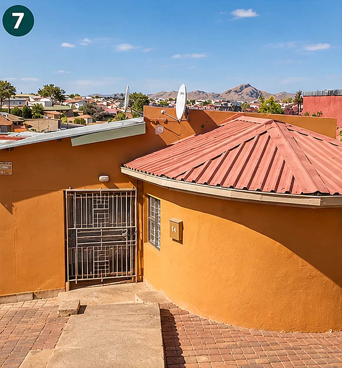 Red tiled roof of the C4 house against the Windhoek hills